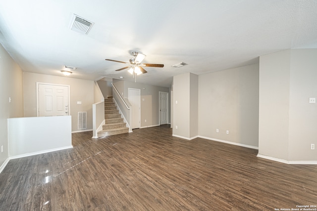 unfurnished living room featuring ceiling fan and dark hardwood / wood-style flooring