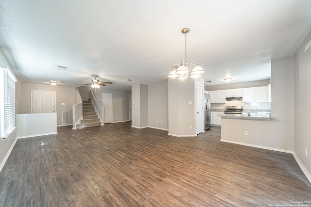 unfurnished living room with ceiling fan with notable chandelier and dark hardwood / wood-style flooring