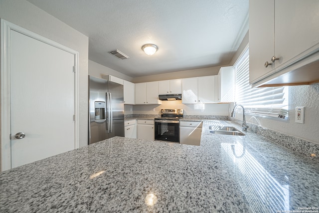 kitchen featuring light stone counters, a textured ceiling, stainless steel appliances, sink, and white cabinetry