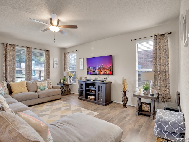 living room featuring a textured ceiling, light hardwood / wood-style flooring, and ceiling fan