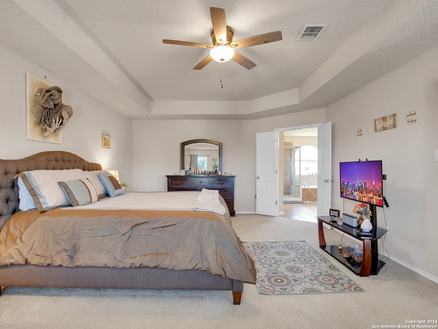 carpeted bedroom featuring ceiling fan, a raised ceiling, and a textured ceiling