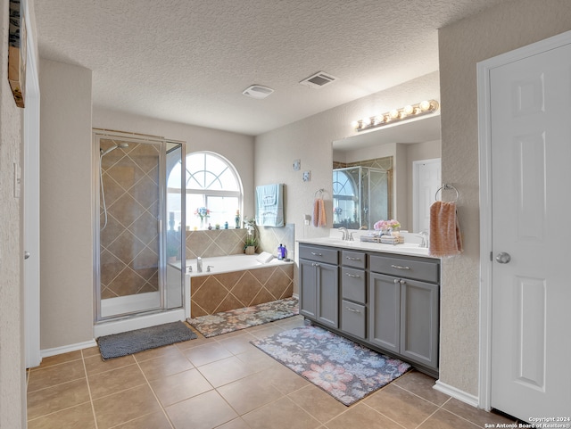 bathroom with tile patterned flooring, vanity, and separate shower and tub