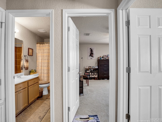 bathroom with walk in shower, vanity, a textured ceiling, and toilet