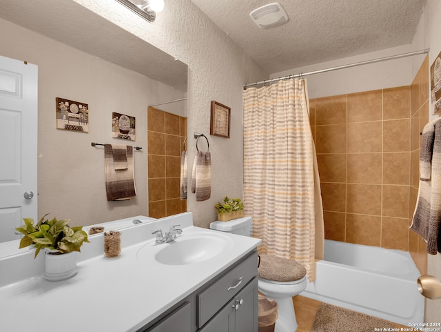 full bathroom with vanity, a textured ceiling, shower / bath combo with shower curtain, tile patterned flooring, and toilet