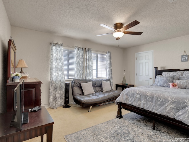 bedroom with ceiling fan, carpet floors, and a textured ceiling