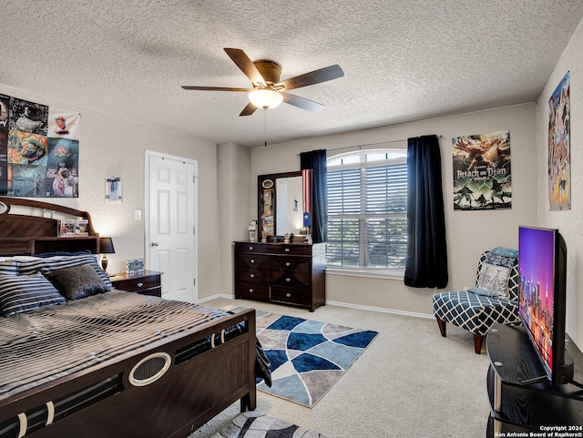 carpeted bedroom with ceiling fan and a textured ceiling