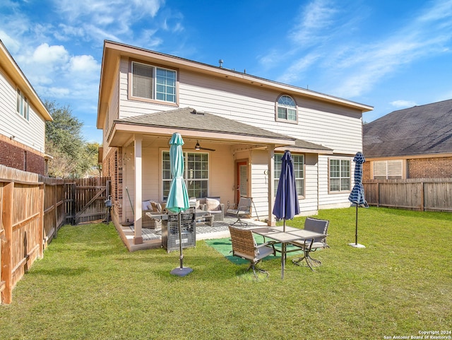 back of property featuring an outdoor living space, a yard, ceiling fan, and a patio area