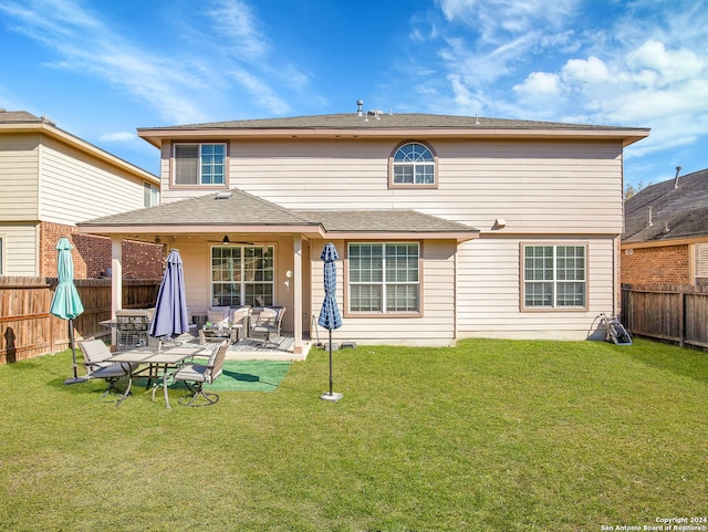 rear view of house featuring a patio area, ceiling fan, and a yard