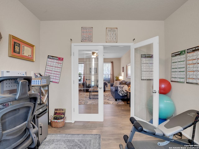 exercise area featuring french doors and hardwood / wood-style flooring