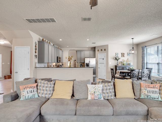 tiled living room featuring a textured ceiling