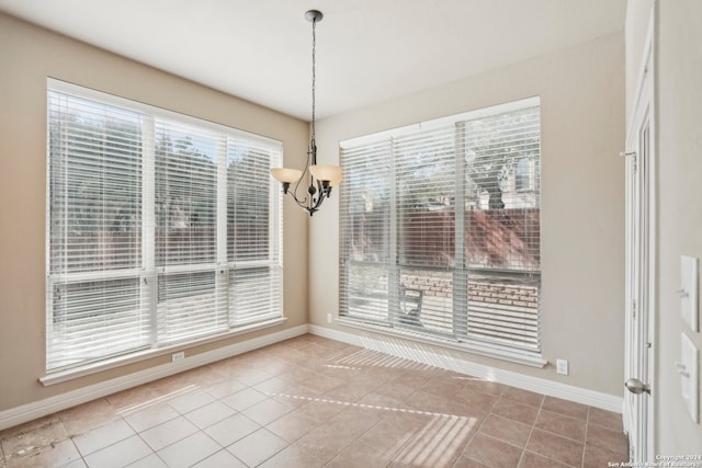 unfurnished dining area with a chandelier, light tile patterned floors, and a healthy amount of sunlight