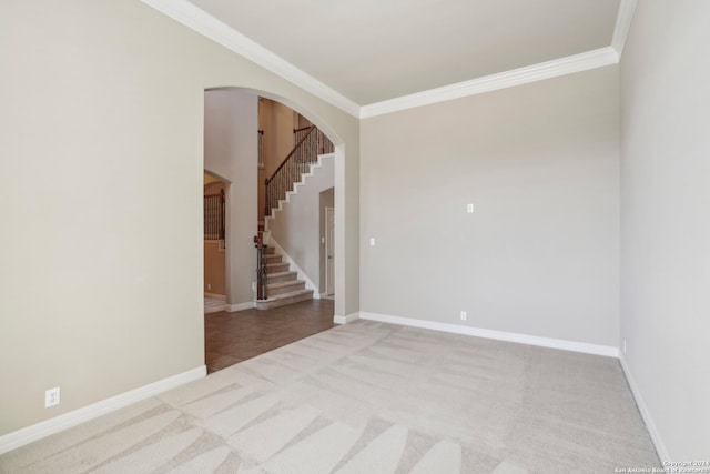 empty room featuring crown molding and light carpet