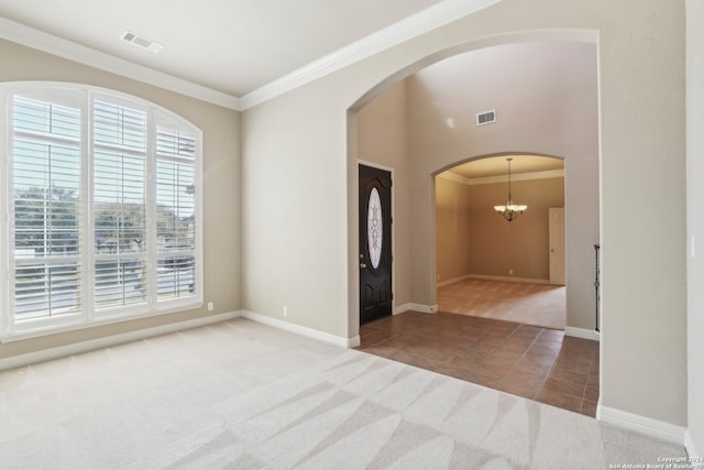 carpeted empty room with plenty of natural light, ornamental molding, and an inviting chandelier