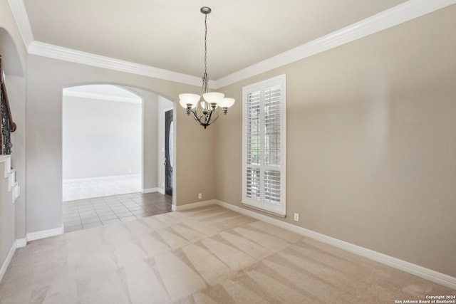 carpeted empty room featuring crown molding and a chandelier