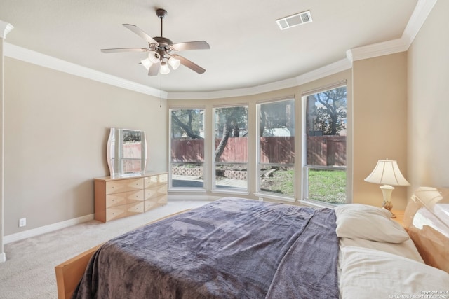 carpeted bedroom with multiple windows, ceiling fan, and crown molding