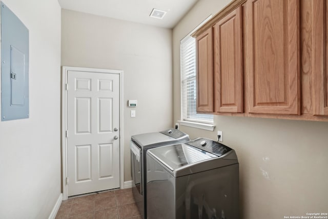 laundry area with cabinets, electric panel, separate washer and dryer, and a wealth of natural light