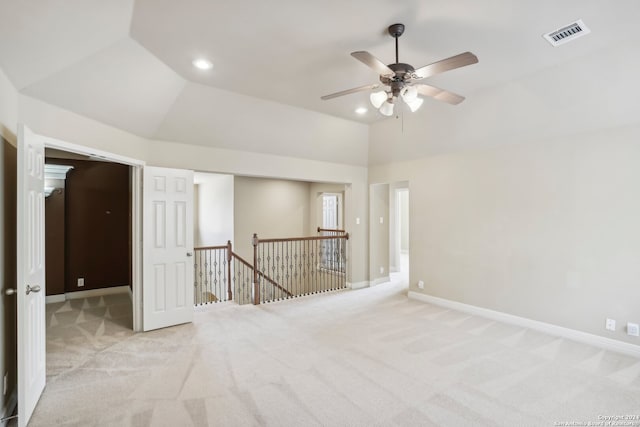 spare room with light carpet, ceiling fan, and vaulted ceiling