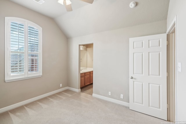 unfurnished bedroom with light carpet, ensuite bathroom, vaulted ceiling, and ceiling fan