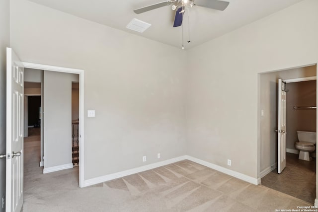 unfurnished bedroom featuring light carpet, ensuite bath, and ceiling fan