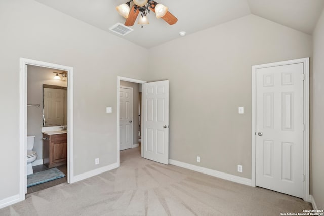 unfurnished bedroom featuring ceiling fan, light carpet, connected bathroom, and vaulted ceiling