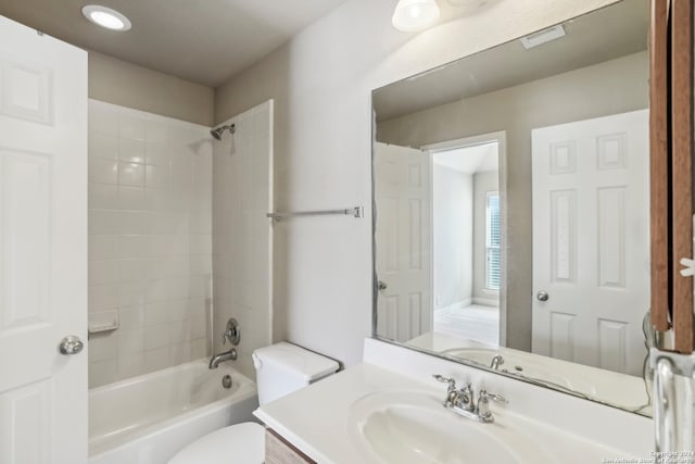 full bathroom with toilet, vanity, and tiled shower / bath