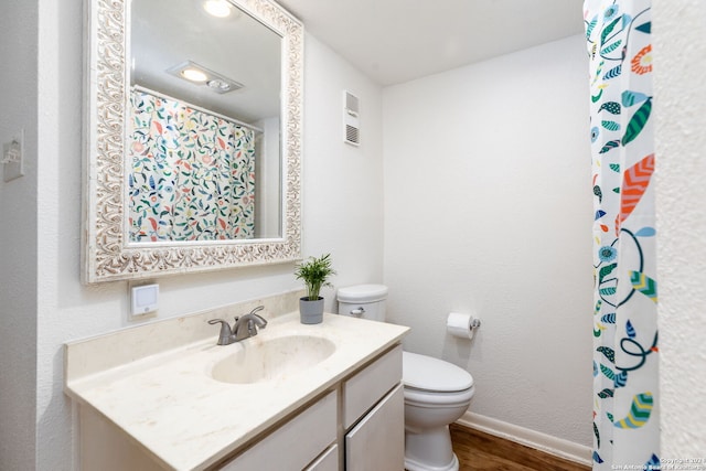 bathroom with hardwood / wood-style flooring, vanity, and toilet