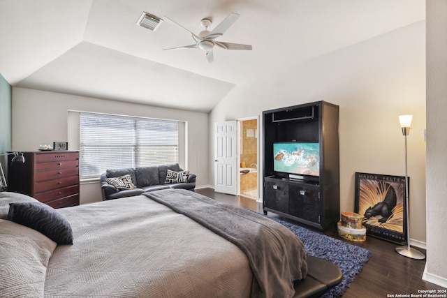 bedroom featuring dark hardwood / wood-style flooring, ensuite bath, ceiling fan, and vaulted ceiling