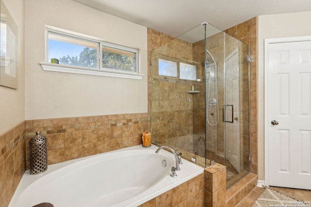 bathroom with independent shower and bath and a textured ceiling