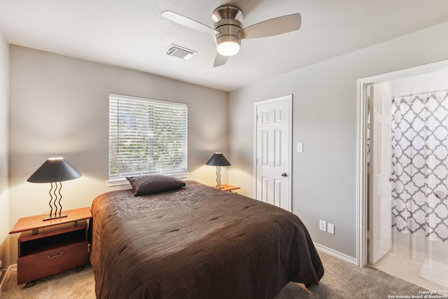 bedroom featuring ceiling fan, ensuite bathroom, and light carpet