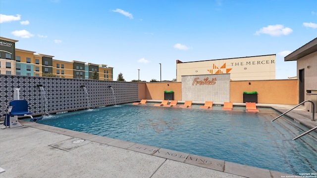 view of pool with pool water feature and a patio