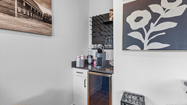 bar with white cabinetry and beverage cooler