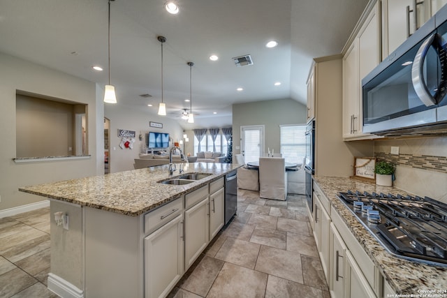 kitchen with appliances with stainless steel finishes, backsplash, sink, pendant lighting, and a center island with sink