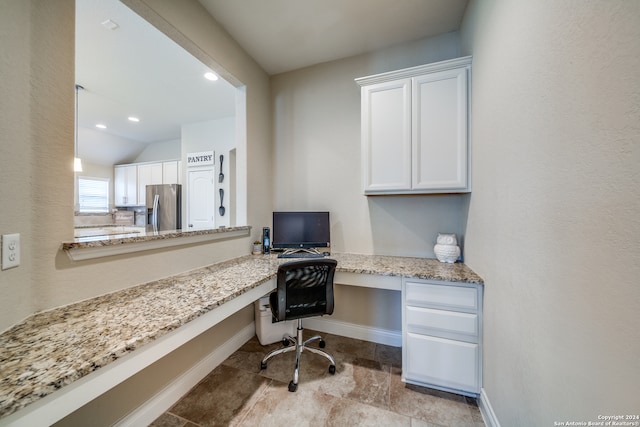 home office with built in desk and vaulted ceiling