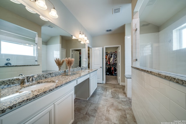 bathroom featuring tiled shower and vanity