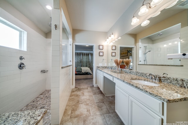 bathroom with vanity and a tile shower