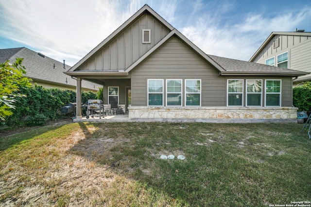 back of property with a patio area and a lawn