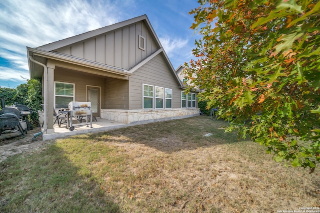 rear view of house featuring a patio area and a yard