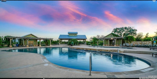 pool at dusk featuring a patio area