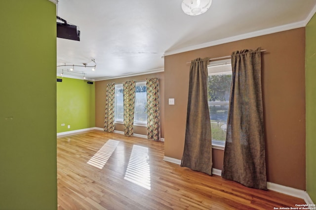 unfurnished room featuring wood-type flooring and ornamental molding