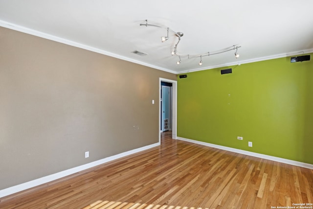 unfurnished room with light hardwood / wood-style flooring, track lighting, and ornamental molding