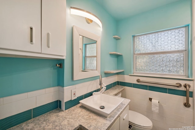 bathroom with a healthy amount of sunlight, tile walls, and toilet