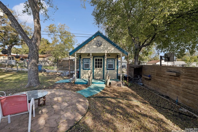 back of house featuring an outbuilding and a patio