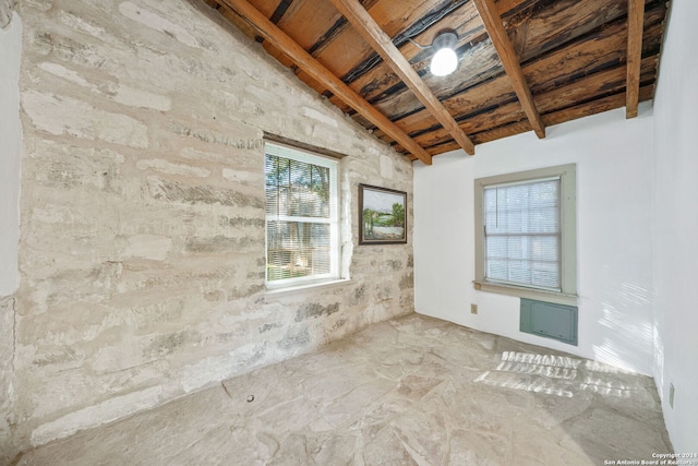 unfurnished room with lofted ceiling with beams