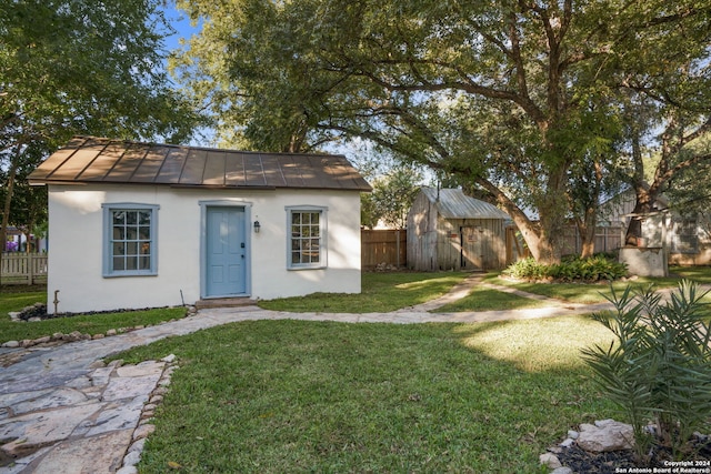 exterior space featuring an outdoor structure and a front yard