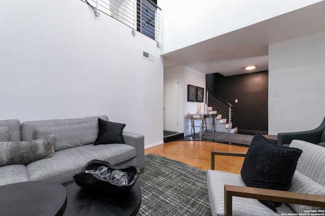 living room featuring a high ceiling and wood-type flooring