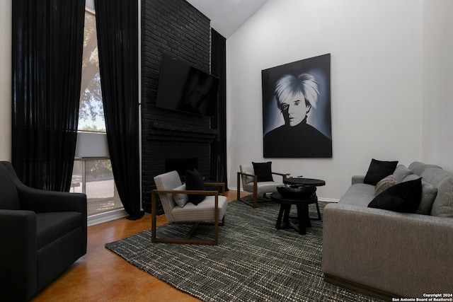 living room with a brick fireplace and lofted ceiling