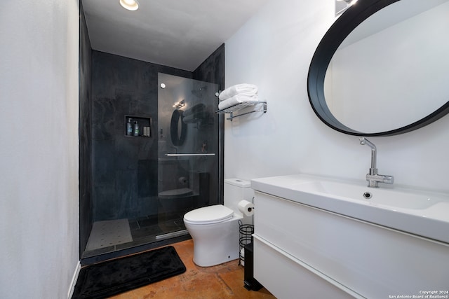 bathroom with tiled shower, vanity, and toilet