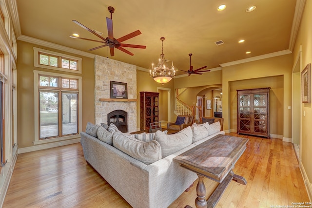 living room with a fireplace, ceiling fan with notable chandelier, light hardwood / wood-style flooring, and crown molding