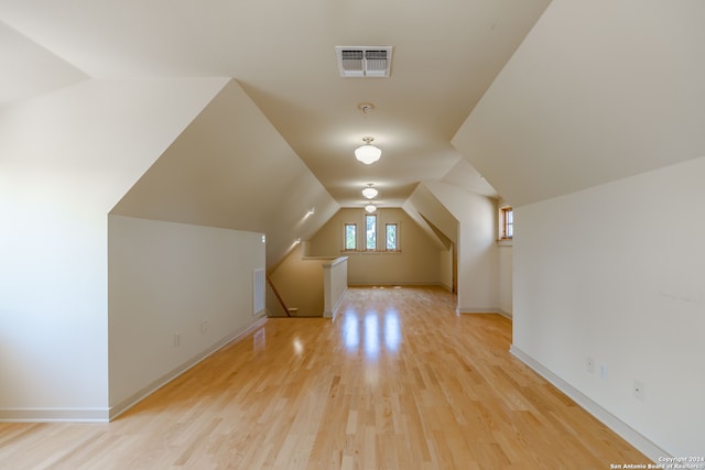 additional living space with vaulted ceiling and light wood-type flooring