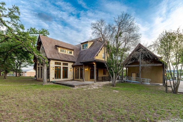 back of house featuring a patio area and a yard